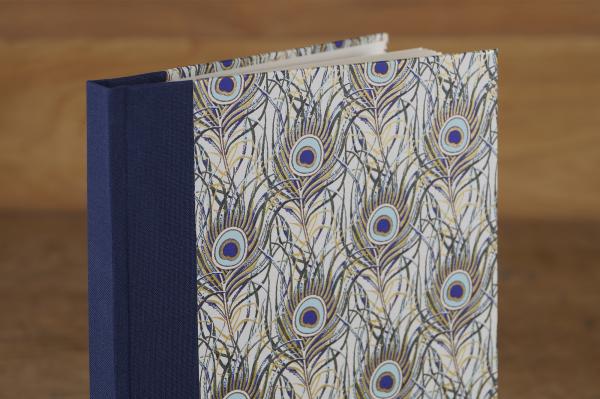 Hardcover Notizbuch mit Pfauenfedern blau und gold, blauer Geweberücken